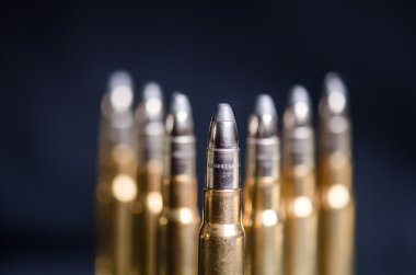 Bir bardak yansıma ile koyu mavi bir arka plan üzerinde Mühimmat. Yakından kapatın. Silah. Mermi 