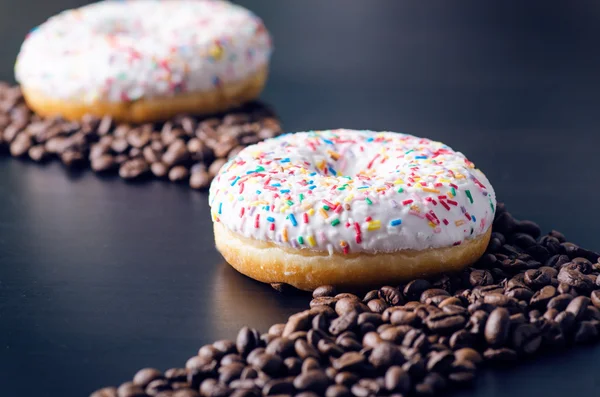 Donut mit Streusel und weißem Eis. Donuts Hintergrund. Kuchen und Süßes. Lebensmitteldetails. Nahaufnahme — Stockfoto