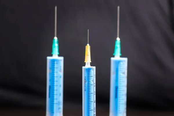 Lékařská injekce na tmavém pozadí. Léky s plastickým očkovacím zařízením. Zdraví a péče. Očkování. Lékařské zázemí. Studio izolováno. Fobie — Stock fotografie