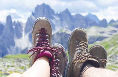 Adam yürüyüşçü bir yere uzanır. Arka plan gibi zirveler. Güneşli bir gün. Trekking botları. Lens parlaması. Başarılı backpacker bir görünüm keyfini çıkarın. 