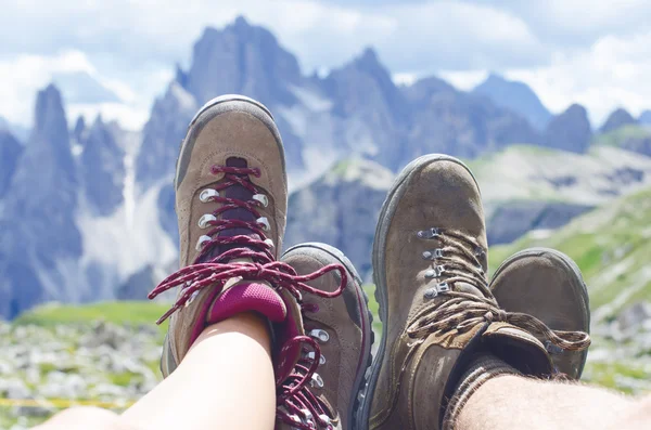 Adam yürüyüşçü bir yere uzanır. Arka plan gibi zirveler. Güneşli bir gün. Trekking botları. Lens parlaması. Başarılı backpacker bir görünüm keyfini çıkarın. 