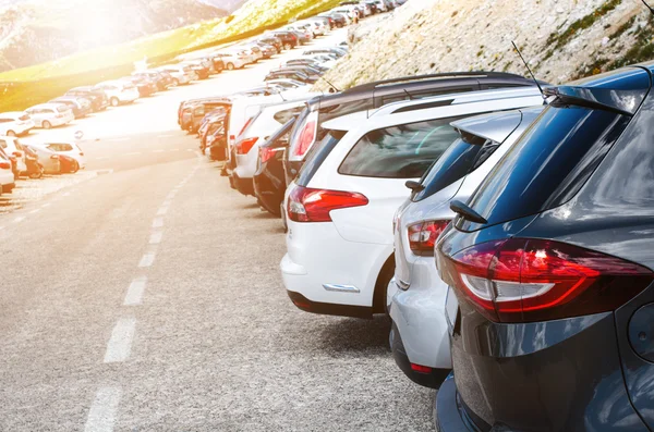 Arabalar Dağları'nın ortasında bir park yerinde. Güzel bir güneş ışığı araçlarda. Ulaşım arka plan 