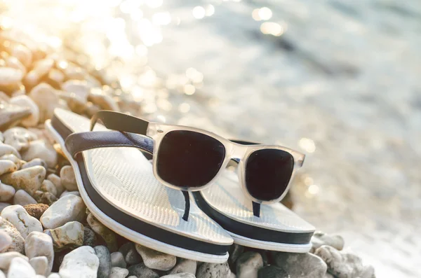 Siyah bir taş üzerinde güneş gözlüğü yansıyor. Gözlük gölge. Güneş ışığı. Yaz konsepti.