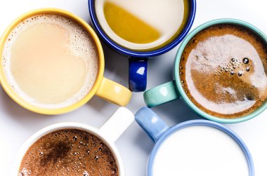 Bir fincan kahve, süt, meyve suyu, kapuçino. Beyaz bir arka plan üzerinde izole edilmiş. Renkli bardaklar. Gözlükler daire içine yerleştirilir. Enerji arka planı. 