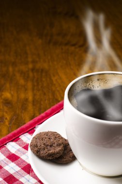 Kadınlar ahşap arkaplanlı kahveye sos bisküvisi koyar. 