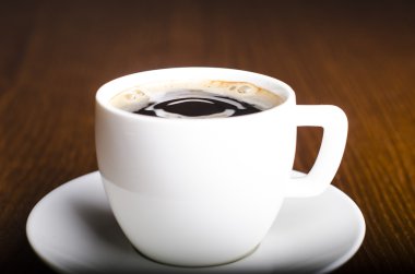 Kadınlar ahşap arkaplanlı kahveye sos bisküvisi koyar. 