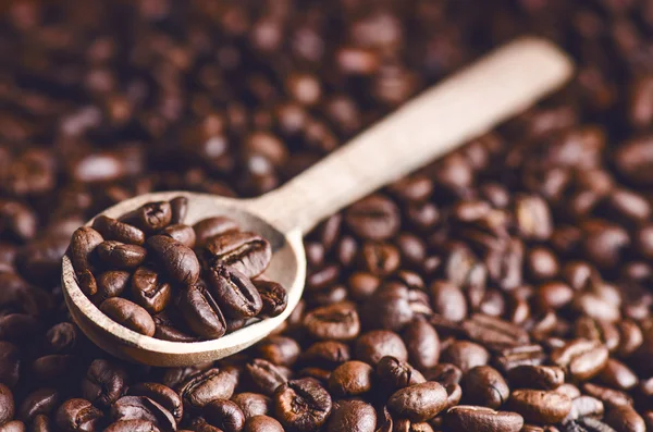 Sked kaffebönor. Bakgrund. Energi. Råa kaffebönor. Detaljerad produkt. Varm dryck. Närbild. Skörd. Naturlig bakgrund. Livsstil. Kaffepaus på morgonen. Träsked. Steam — Stockfoto