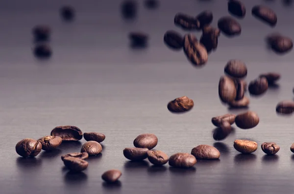 Kaffebönor på svart bakgrund. Levitation av kaffebönor. Råa kaffebönor. Detaljerad produkt. Varm dryck. Närbild. Skörd. Naturlig bakgrund. Energi — Stockfoto