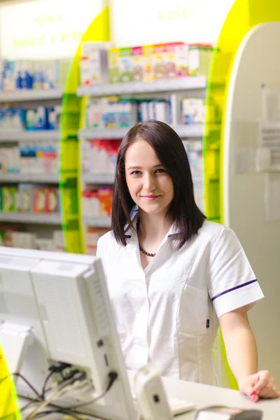 Kobieta chemik farmaceuta Pokaż pigułki. Apteka apteka jest podłoże. Ładny, młody laborant. — Zdjęcie stockowe