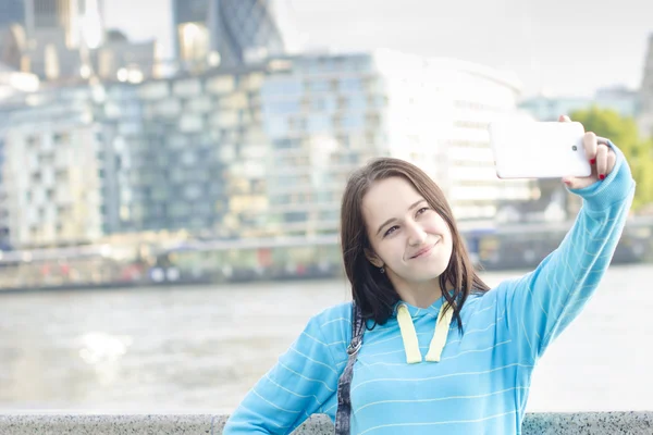 Mujer toma un selfie en una ciudad — Foto de Stock