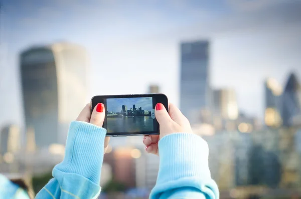 Mujer toma un selfie en una ciudad — Foto de Stock