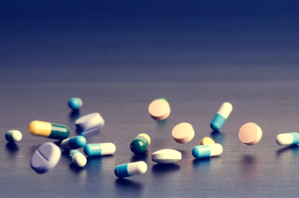 Eczane zemin üzerine koyu bir tablo. Havaya yükselme tablet. Hapları. Tıp ve sağlıklı. Kapsül kapatın. Aynı tür haplar 