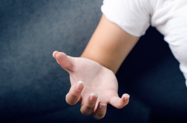 Kadın bir hareketi el ile göstermek. Kadının eli. Spazm el. Koyu mavi arka plan.