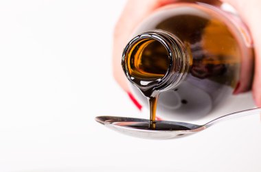 bir sıvı bir kaşık dökme. Doğal yeşil arka plan. Eczane ve sağlıklı arka plan. Tıp. Öksürük ve soğuk ilaç. 