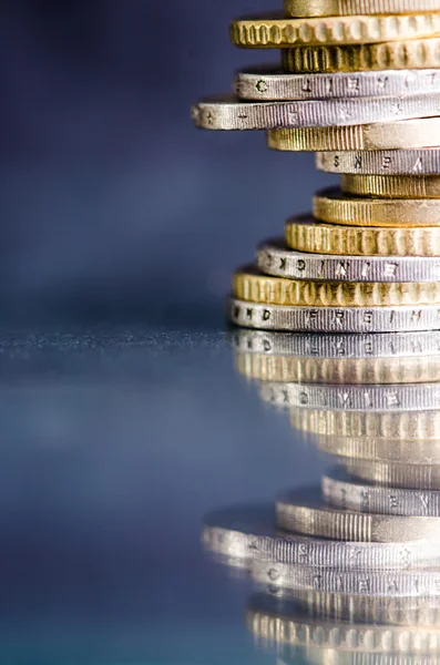 Euro-Geld. Münzen sind isoliert auf einem dunklen Hintergrund mit Reflexion in einem Glas. Währung Europas. Geldbilanz. Gebäude aus Münzen. — Stockfoto