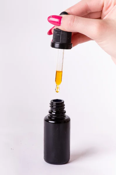 Bir damlalık şişe bir damla. Beyaz bir arka plan üzerinde izole. Eczane ve sağlıklı arka plan. Tıp. . Kadının el tutmak bir damlalık 