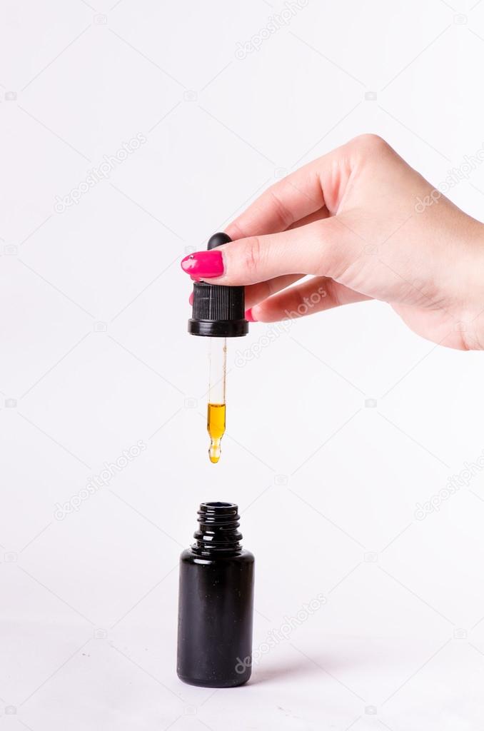 Drops from a dropper in a bottle. Isolated on a white background