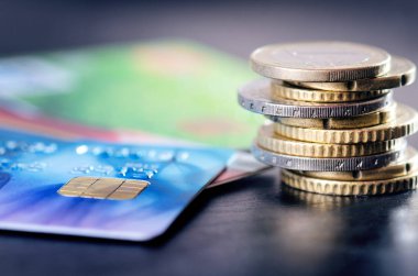 Euro para ve kredi kartları karanlık bir arka plan üzerinde yalıtılır. Avrupa para birimi. Bakiye para. Paralar binadan. 