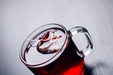 Fincan çay çay poşeti ile. Bir doğal, koyu arka plan üzerinde. Açık cam Kupası mı. 