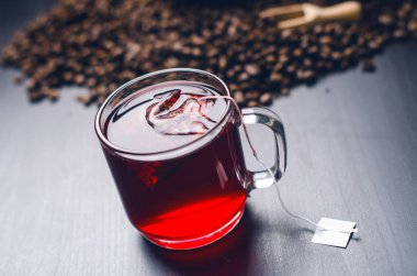 Fincan çay çay poşeti ile. Bir doğal, koyu arka plan üzerinde. Açık cam Kupası mı. 