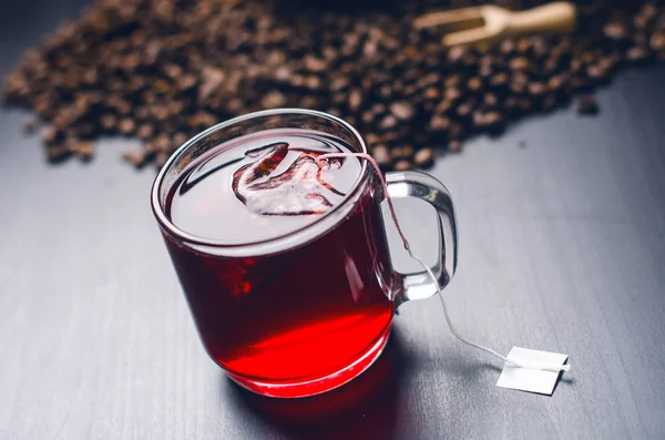 Fincan çay çay poşeti ile. Bir doğal, koyu arka plan üzerinde. Açık cam Kupası mı. 