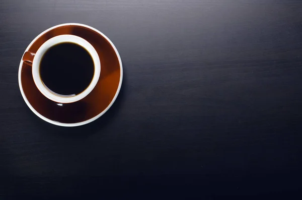 Cup of coffee on a dark table. Concept of business. Laptop, headphones, watch. — Stock Photo, Image