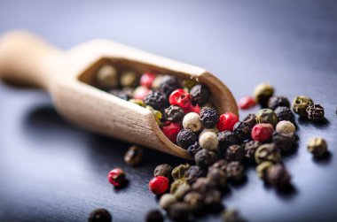 Renkli baharat bir koyu mavi masada. Kavram mutfak ve pişirme. Bir tahta kaşık baharatlı. 