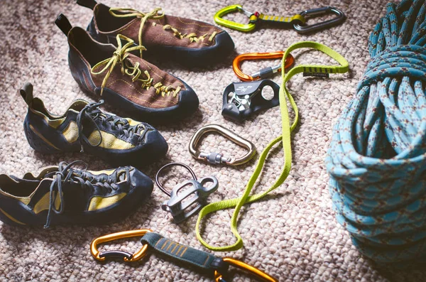 Climbing and mountaineering equipment on a carpet. Shoes, carbine, rope, lope, ascend-er. Concept of outdoor and extreme sport. — Stock Photo, Image