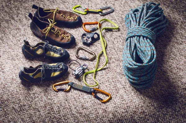 Climbing and mountaineering equipment on a carpet. Shoes, carbine, rope, lope, ascend-er. Concept of outdoor and extreme sport. — Stock Photo, Image
