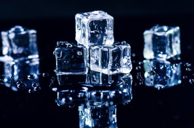 Buzlu küpleri yansıma ile siyah bir tabloda erime. Su. Buz erime. 