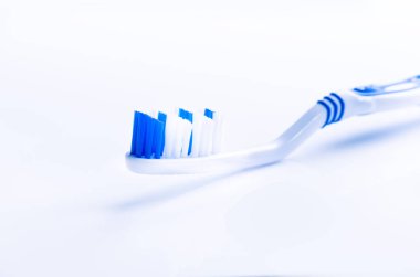 Beyaz bir arka planda yansıma ve diş macunu ile izole diş fırçası. Mavi plastik diş fırçası. Diş Hekimliği kavramı. 