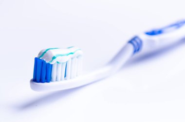 Beyaz bir arka planda yansıma ve diş macunu ile izole diş fırçası. Mavi plastik diş fırçası. Diş Hekimliği kavramı. 