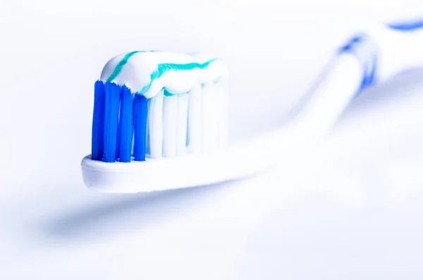 Zahnbürste isoliert auf weißem Hintergrund mit Reflexion und Zahnpasta. blaue Zahnbürste aus Kunststoff. Konzept der Zahnmedizin. — Stockfoto