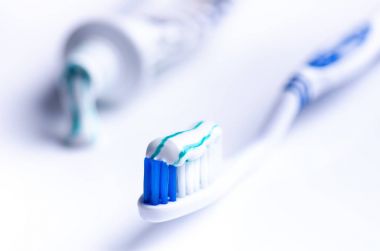 Beyaz bir arka planda yansıma ve diş macunu ile izole diş fırçası. Mavi plastik diş fırçası. Diş Hekimliği kavramı. 