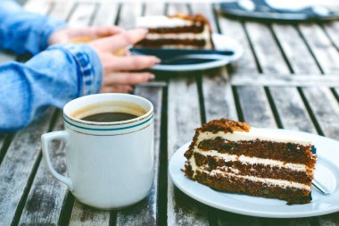  Kahve kupa ve kek üzerine ahşap bir vintage tablo. Hipster kavramı. Kadın bir kahve iç. Bardak americano ve macchiato. 