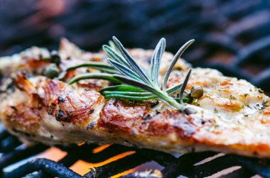 Baharat ve biberiye ile bir ızgarada tavuk fileto ızgara. Alevli ızgara sebze ile marine edilmiş tavuk göğsü. Sağlıklı gıda. Barbekü sos.