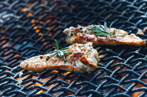 Filetes de frango grelhados em uma grelha com especiarias e alecrim. Peito de frango marinado em grelha flamejante com legumes. Comida saudável. Molho para churrasco . — Fotografia de Stock