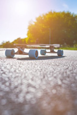 Güneşli havalarda yolda longboard. Kaykay etrafında insanlar. Yolu bir parkta. Kentsel sahne.