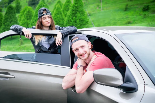 Pareja joven y feliz, amigos sentados en el coche. Hora de verano. Gente caucásica. Concepto de transporte . — Foto de Stock