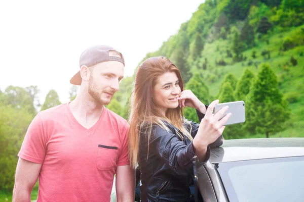 Feliz pareja joven, amigos haciendo selfie mientras están sentados en el coche. Hora de verano. Gente caucásica. Concepto de transporte . — Foto de Stock