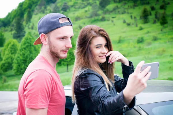 Feliz pareja joven, amigos haciendo selfie mientras están sentados en el coche. Hora de verano. Gente caucásica. Concepto de transporte . — Foto de Stock