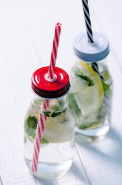 Ev yapımı serinletici su ile limon, limon ve Bahçe beyaz bir tablo üzerinde mentha aromalı. Yaz saati. İçecekler. 