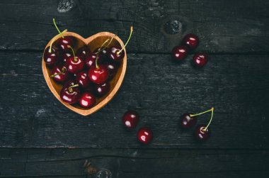 Siyah bir masada kirazlar doğal ahşap bir masa. Taze gıda konsepti. Meyve. Yaz zamanı.