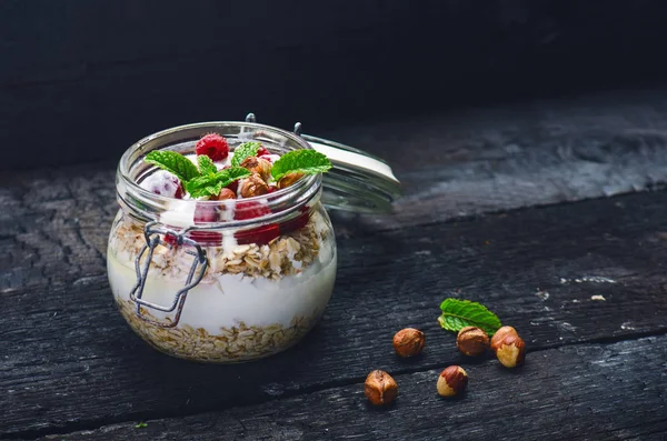 Volle Gläser Müsli Joghurt Himbeeren Nüsse Auf Einem Schwarzen Verbrannten — Stockfoto