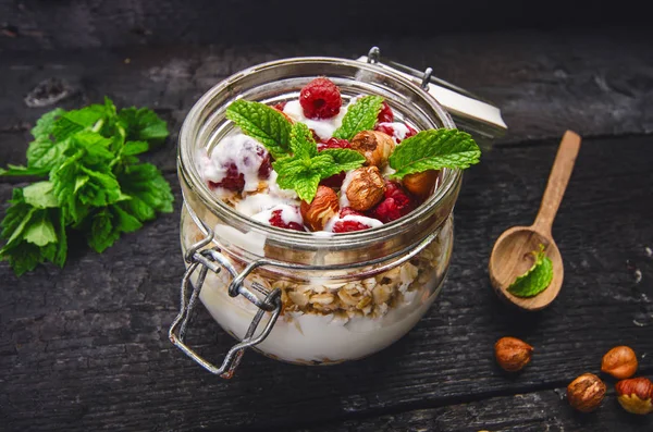 Volle Gläser Müsli Joghurt Himbeeren Nüsse Auf Einem Schwarzen Verbrannten — Stockfoto