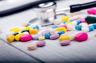 Beyaz bir masada eczane geçmişi. Beyaz ahşap arka planda steteskop. Bir metin için boşluk kopyala. Beyaz arka planda tabletler. Haplar. İlaç ve sağlıklı.. 