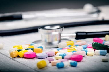 Beyaz bir masada eczane geçmişi. Beyaz ahşap arka planda steteskop. Bir metin için boşluk kopyala. Beyaz arka planda tabletler. Haplar. İlaç ve sağlıklı.. 