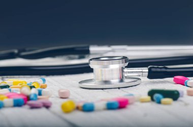 Beyaz bir masada eczane geçmişi. Beyaz ahşap arka planda steteskop. Bir metin için boşluk kopyala. Beyaz arka planda tabletler. Haplar. İlaç ve sağlıklı.. 