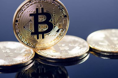 Koyu arkaplanda yansıması olan altın bitcoin sikkeler. Sanal para birimi. Şifreli para birimi. Yeni sanal para.
