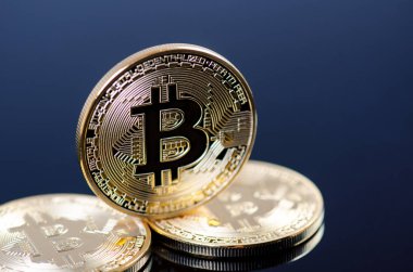 Koyu arkaplanda yansıması olan altın bitcoin sikkeler. Sanal para birimi. Şifreli para birimi. Yeni sanal para.